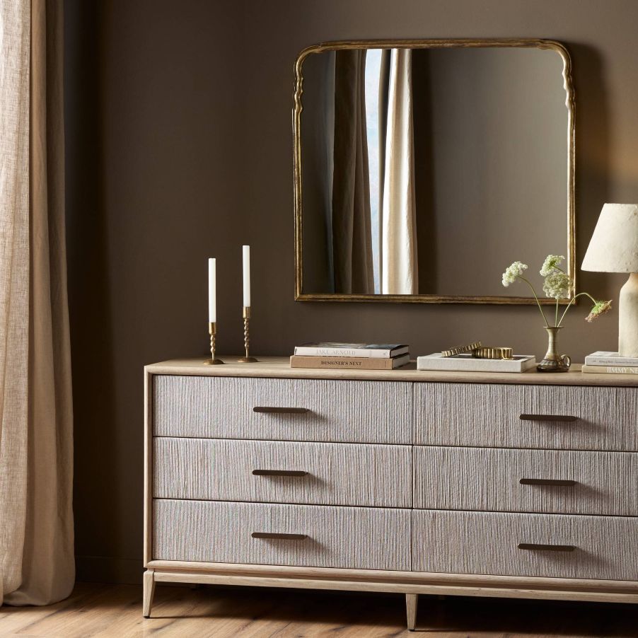 Loire Mantle Mirror above a dresser with decor on it in a room with brown walls and curtains on the side