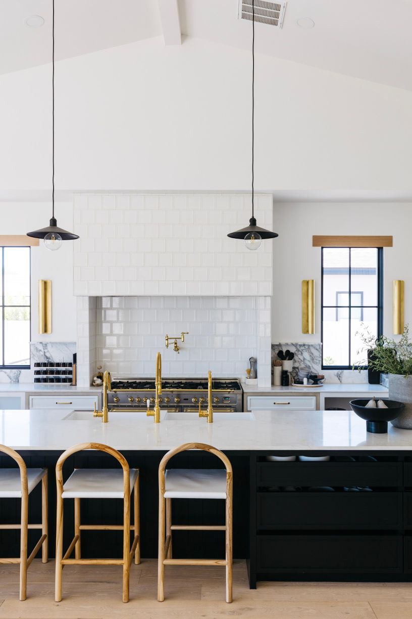 Mccoy pendants hanging in a kitchen over a large island with bar stools