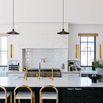 Mccoy pendants hanging in a kitchen over a large island with bar stools