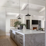 Modern kitchen with McCoy pendants over a marble island and white walls