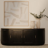 Nicola media tv cabinet against a wall with abstract art and a vase with greenery.