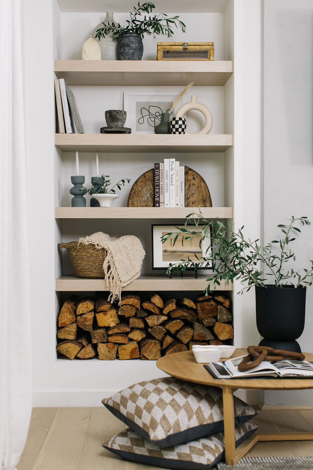 Styled shelves with plants, vases, candles, books, and art.