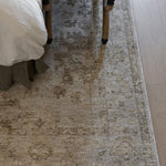 Willa patterned power loomed area rug on a wooden floor with a bed and bench in the background
