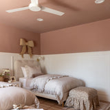 Bedroom with a bed and the Eloise ottoman on a patterned rug.