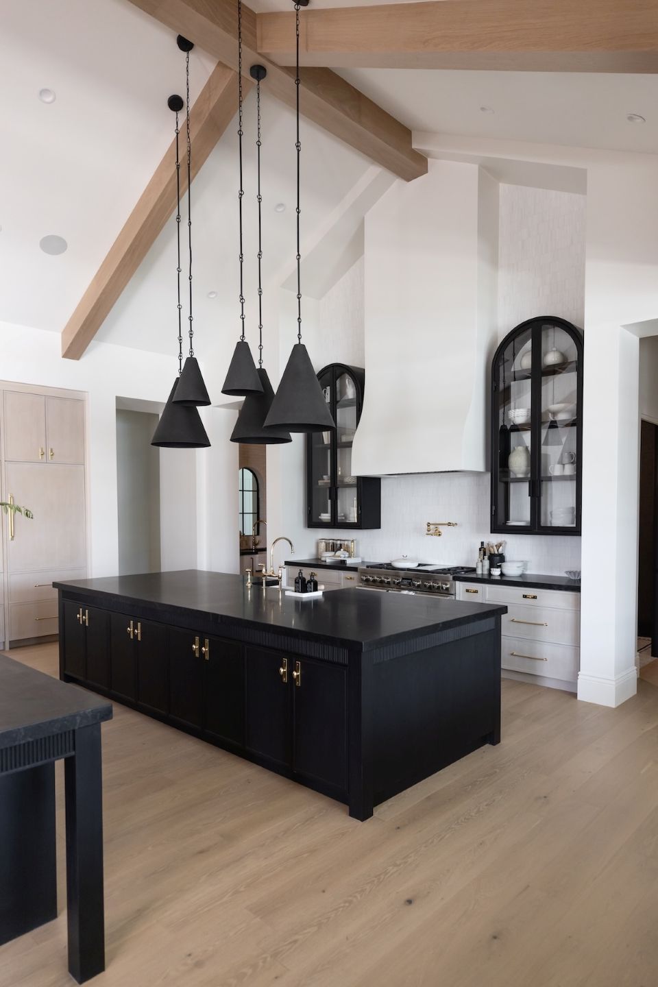 Modern kitchen with black island and pendant lights in two sizes