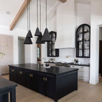 Modern kitchen with black island and pendant lights in two sizes
