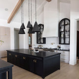 Modern kitchen with black island and pendant lights in two sizes