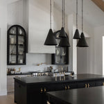 Modern kitchen with black island, black pendant lights, and white walls.