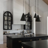 Modern kitchen with black island, black pendant lights, and white walls.