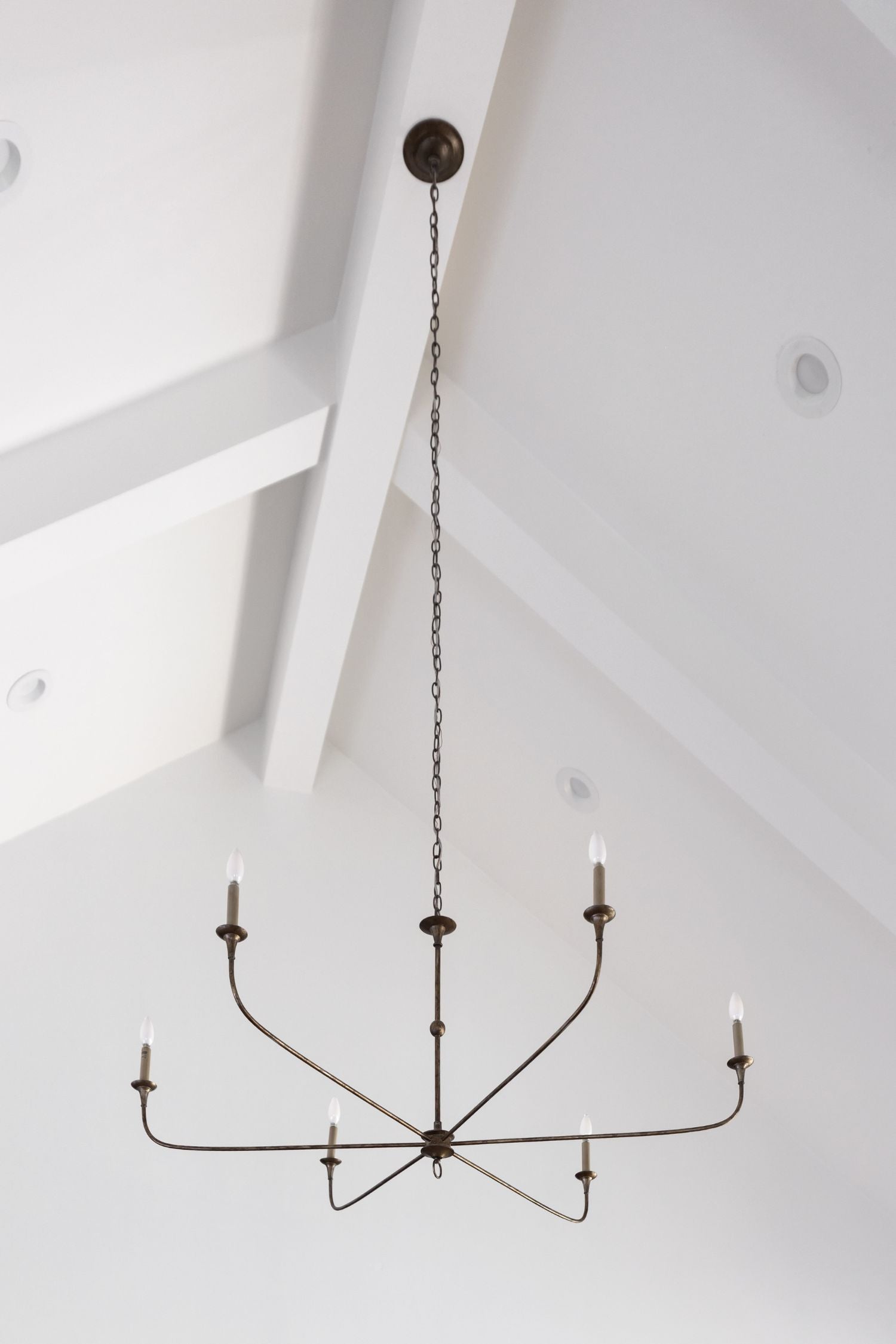 nottaway large modern chandelier hanging from a high white ceiling with beams