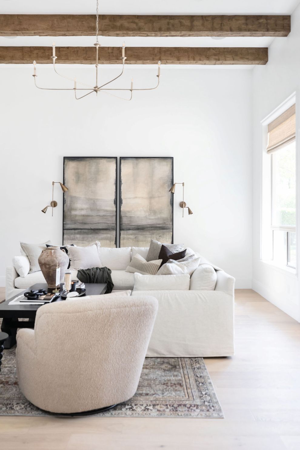 Modern living room with nottaway  large modern chandelier white sofa, beige chair, artwork, rug and decorative elements
