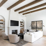 Modern living room with white walls, wooden beams, nottaway large modern chandelier for high ceilings, sofas, chairs, fireplae, tv and other decorative elements