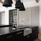 Modern kitchen with black island, pendant lights, and cabinets.