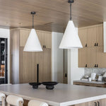 Modern kitchen with wooden cabinets, white countertops, and Grazia pendant lights over kitchen island.
