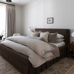 Modern bedroom with a power loomed area rug and bed, side tables, and decorative pillows.
