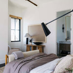 Modern bedroom with a Regina Andrew Talon chandelier, bed, lamp, and window.