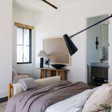 Modern bedroom with a Regina Andrew Talon chandelier, bed, lamp, and window.