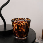 Rare tortoise print candle holder on a black surface with a white background