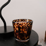 Rare tortoise print candle holder on a black surface with a white background