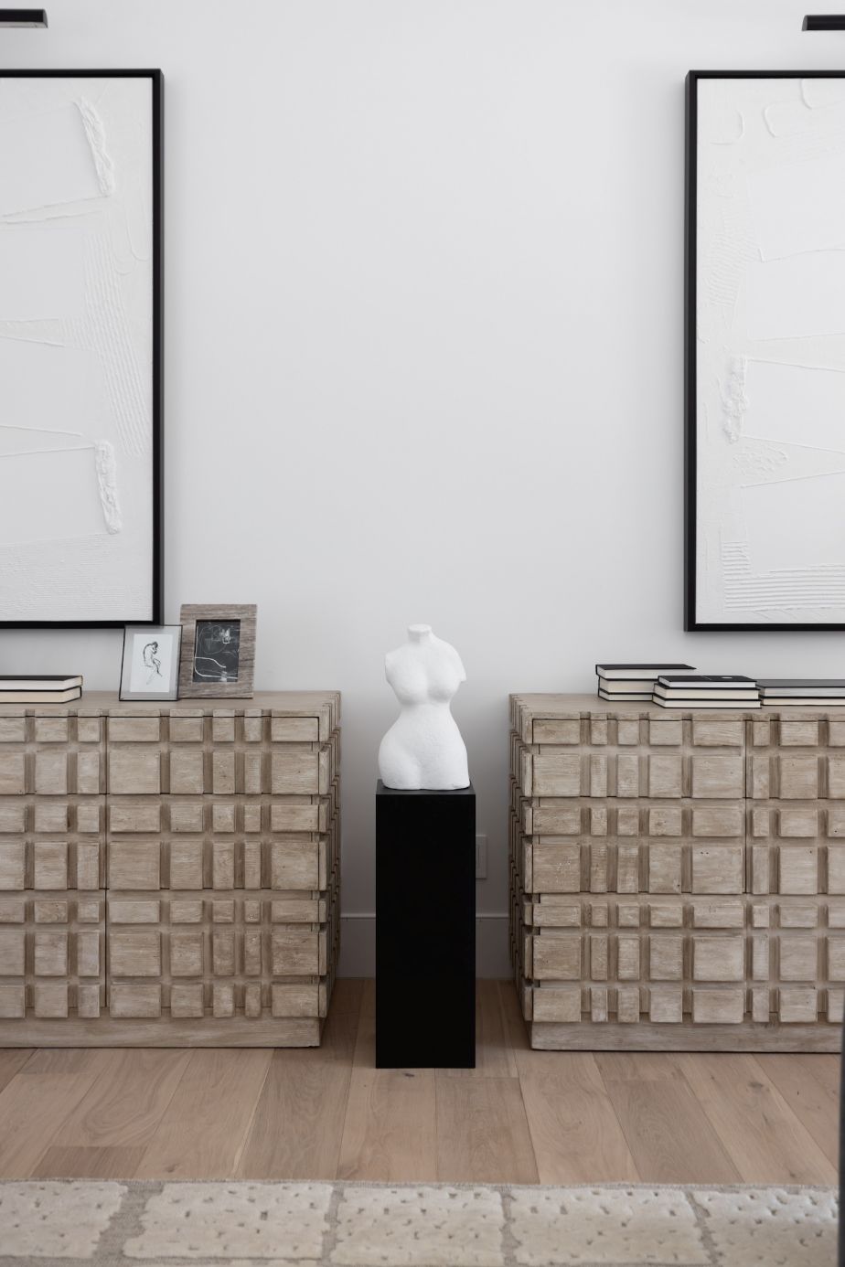 Two Oslo statement dressers beside each other with books on top and a statue in between and art on the walls behind them